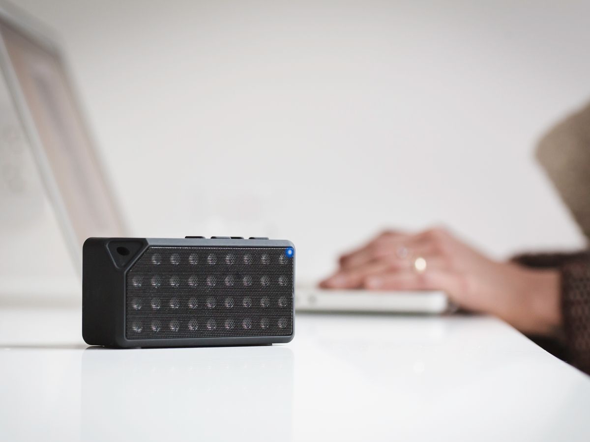 Wireless desktop speaker beside a laptop
