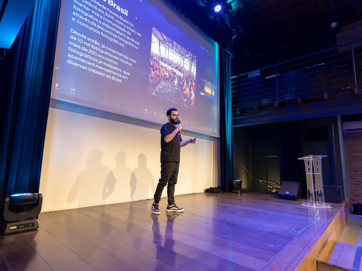 Presenter speaking to a room with slides on screen