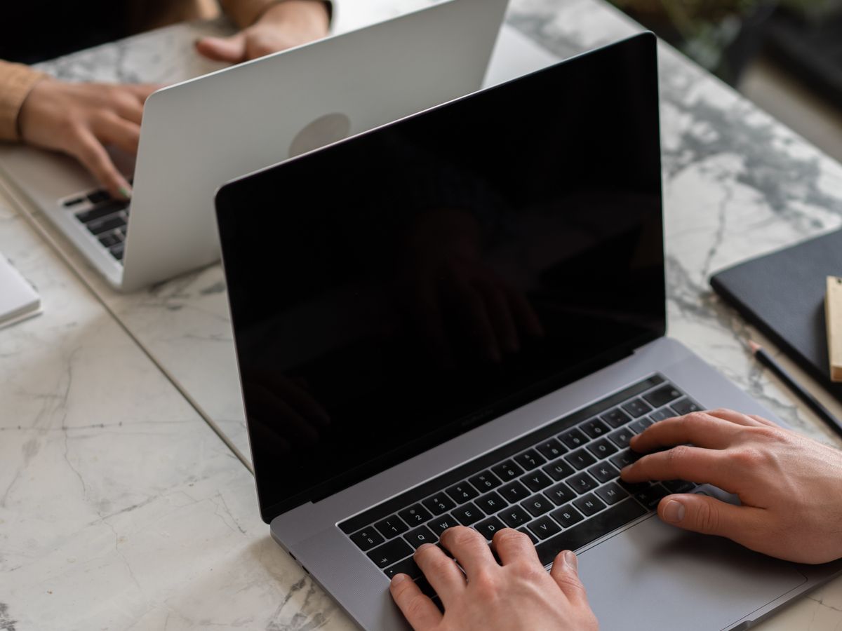 Two colleagues working on business laptops in a modern office