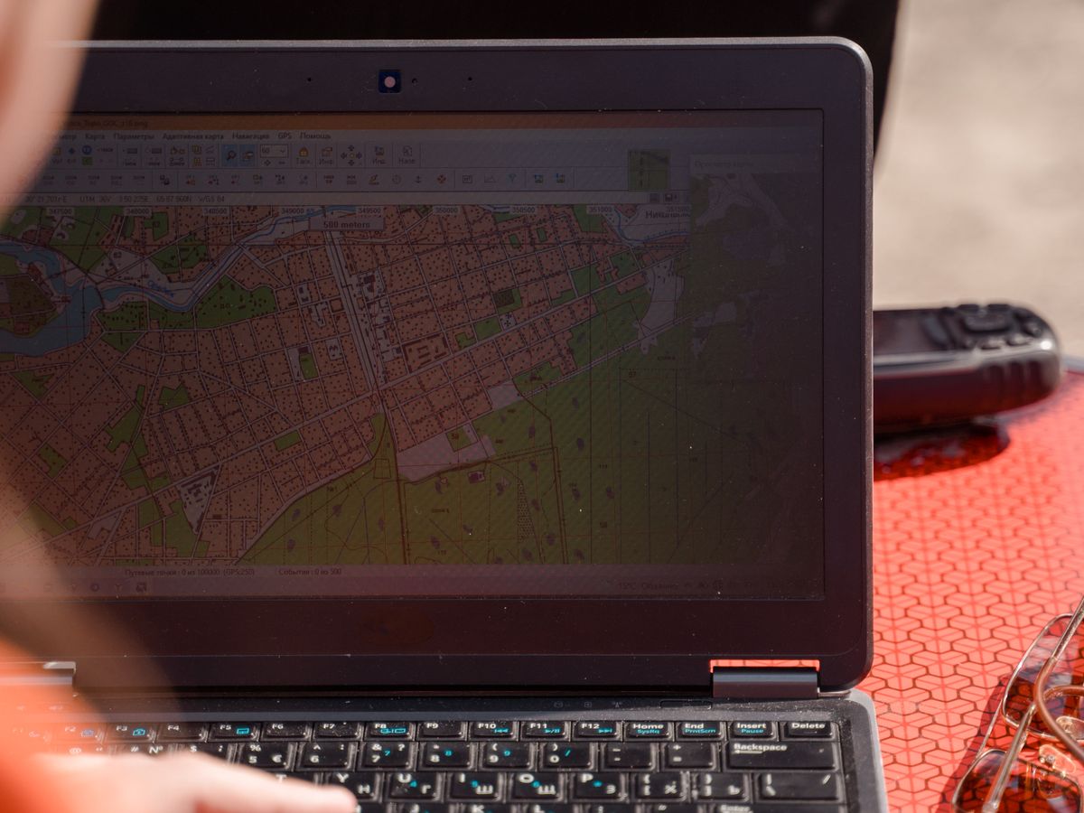 Field surveyor using a rugged laptop outdoors on site