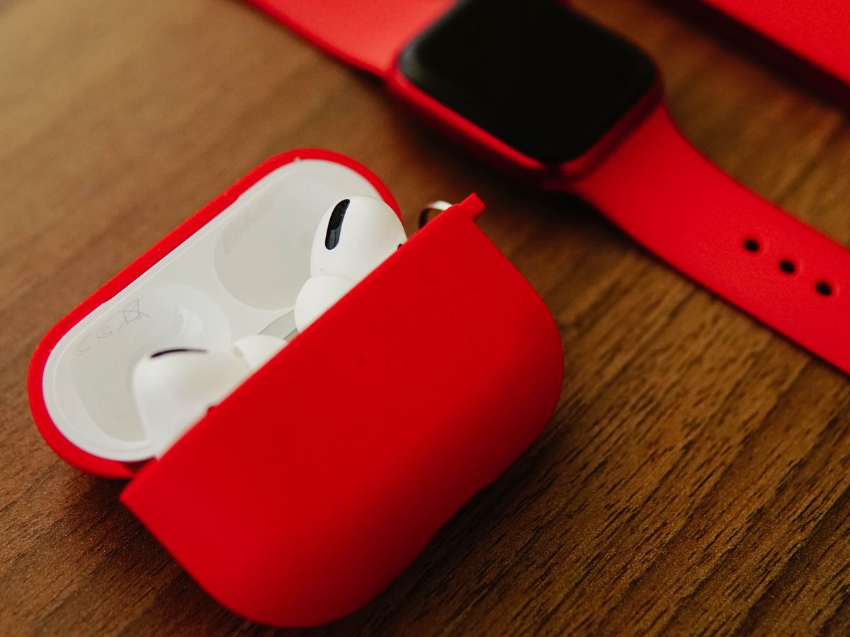 Wireless earbuds and a smartwatch on a desk