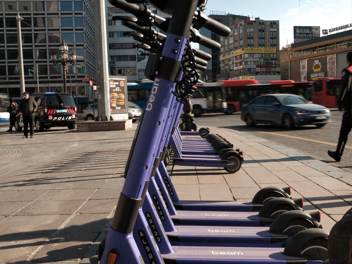 Electric scooters lined up on a city pavement