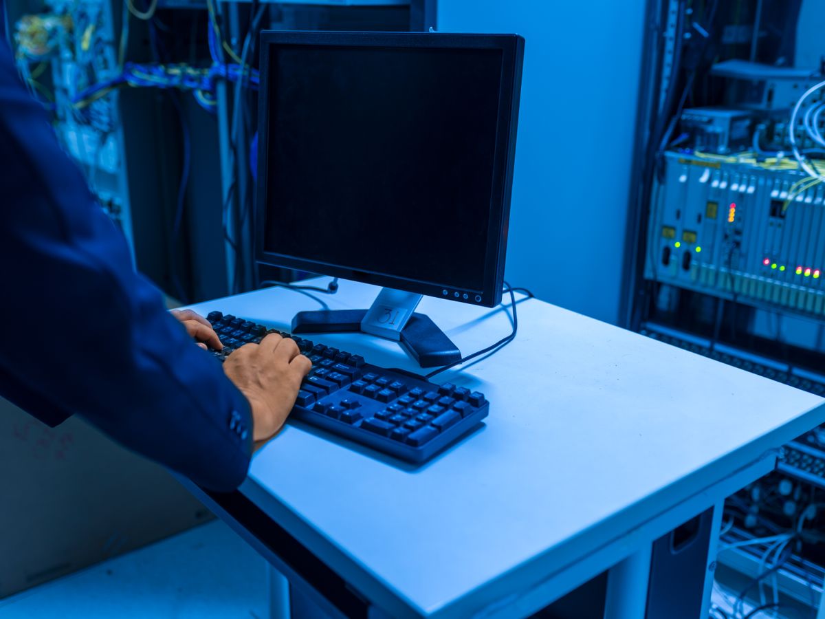 IT technician managing servers from a console in a server room