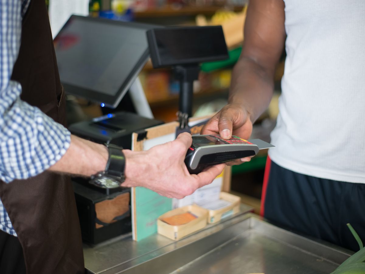 Customer paying at a checkout counter with the terminal in view