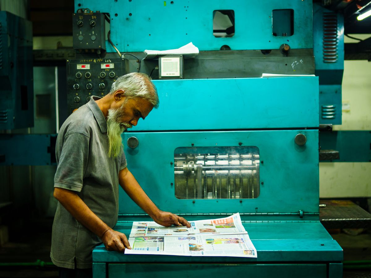 Operator checking freshly printed large-format sheets